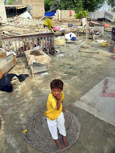 Pakistan Flood Update: A girl sits amid remains of her destroyed house, Pakistan floods