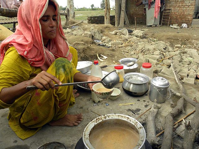 Pakistan Flood Update: A woman displaced from floods, prepares tea amid remains of her house