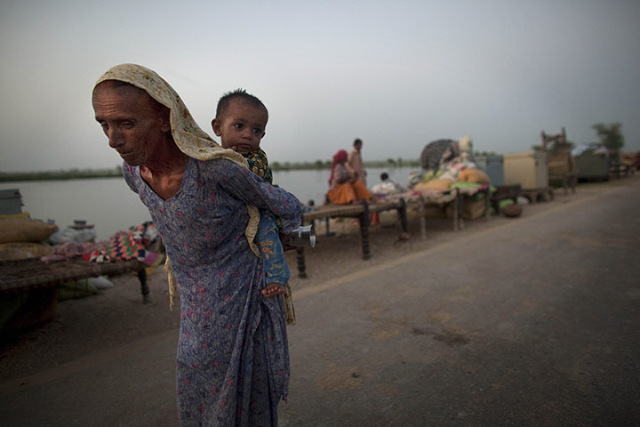 Pakistan Flood Update: A Pakistani woman  forced to flee her village carries a grandchild