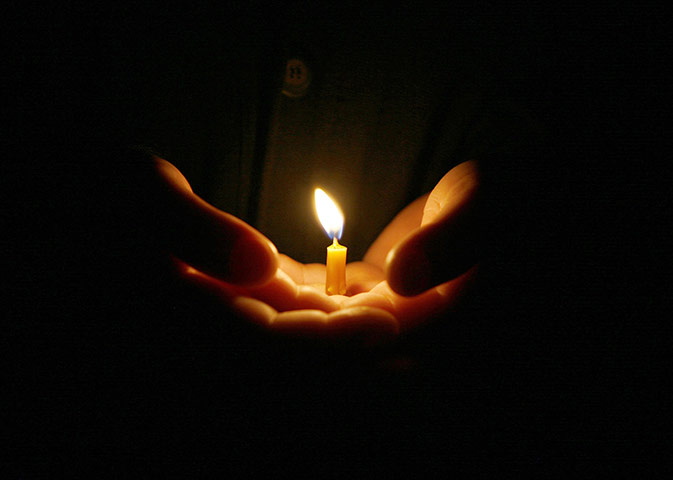 24 hours in pictures: An Orthodox nun holds a candle during a procession in Jerusalem