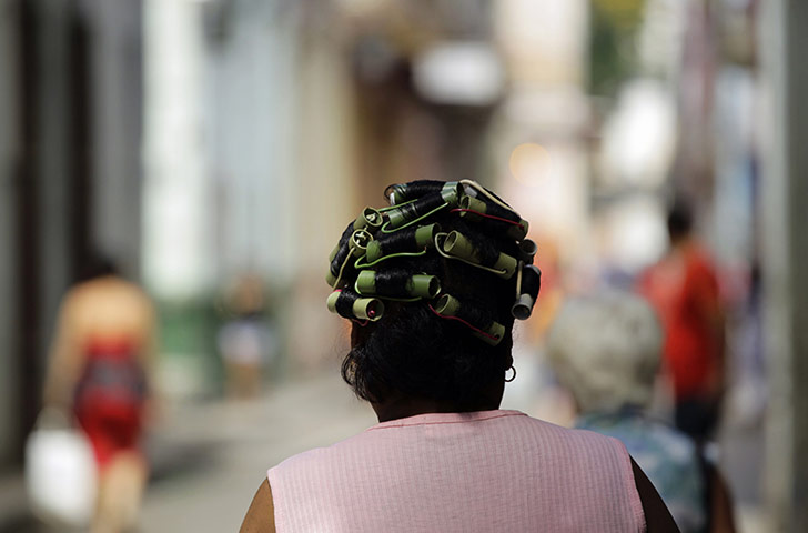 24 hours in pictures: Havana, Cuba: A woman wears hair curlers made from pipes and cables