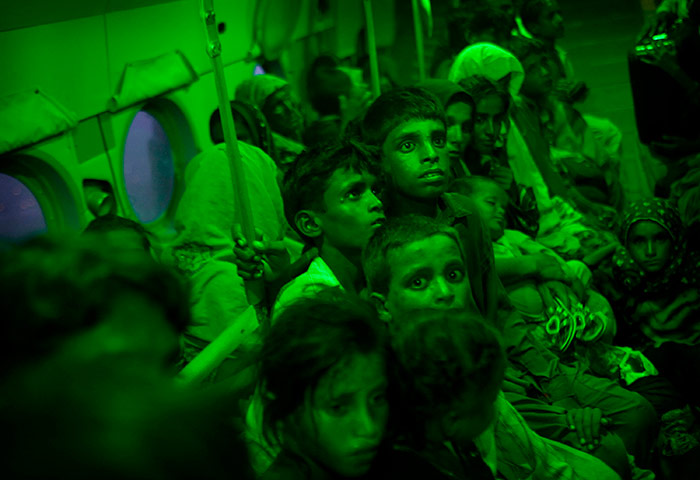 pakistan aftermath: Pakistanis sit in green glow of interior light in Afghan Army helicopter