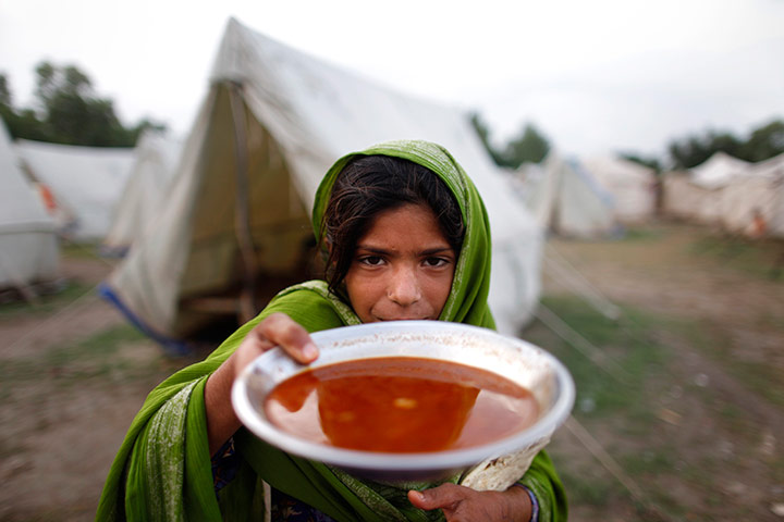 pakistan aftermath: A girl holds up her evening meal in Nowshera