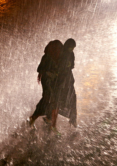 24 hours in pictures: Hyderabad, India: Women walk in the pouring rain 