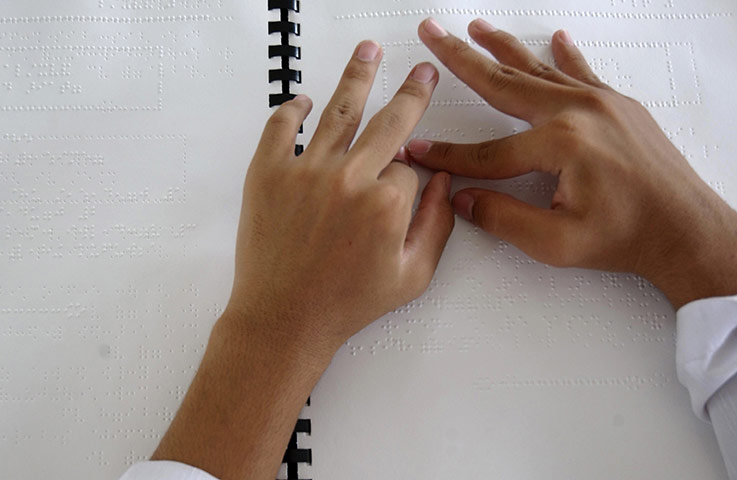 Ramadan Update: A student reads Islam's holy book the Quran in Braille at a special school