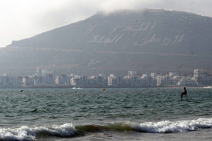 Ramadan Update: A Moroccan sits on a chair he placed in the sea on a beach in Agadir