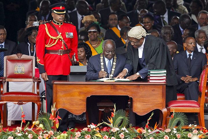 Kenya Constitution: Mwai Kibaki (C) signs the new constitution into law