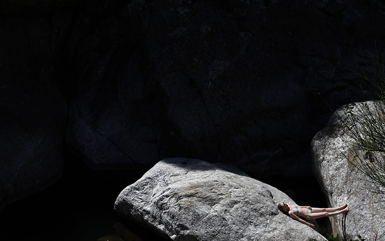 24 hours in pictures: A woman sunbathes between two rocks in the Gorges D'Heric, France