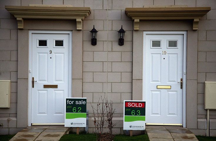 Business week in pictures: 'For Sale' and 'Sold' signs are displayed outside houses by Persimmon