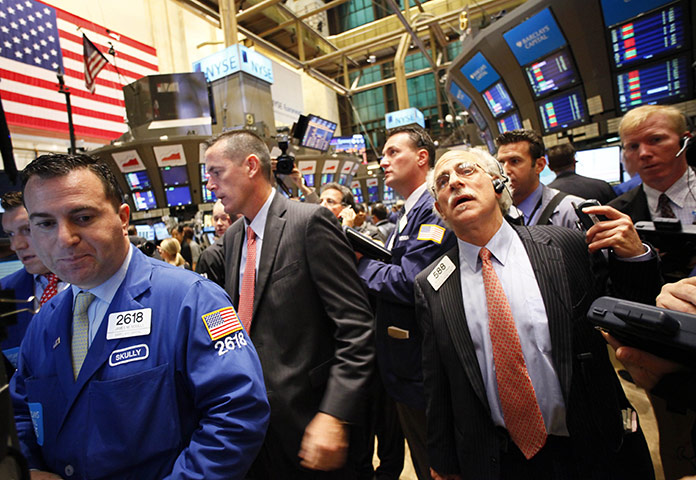 Business week in pictures: Traders at the New York Stock Exchange follow the stock price for Potash