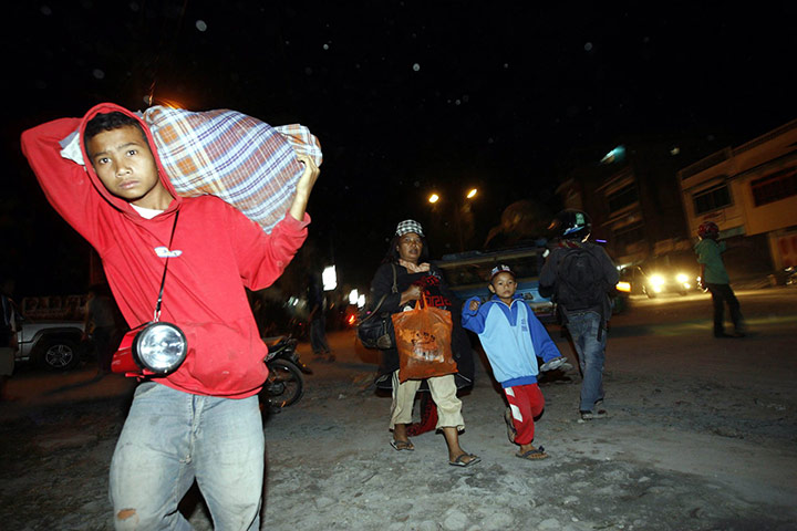 Sinabung volcano: An Indonesian man carries his bag as he flees outside the city of Medan