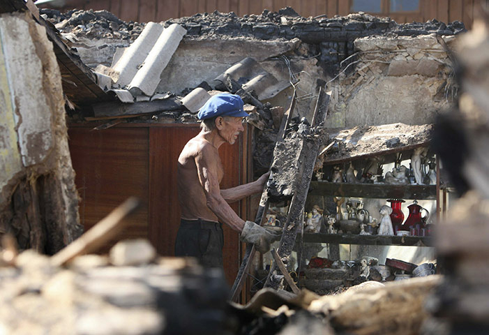 russian fire update: A Russian man walks through the remains of his burnt out home in Voronezh