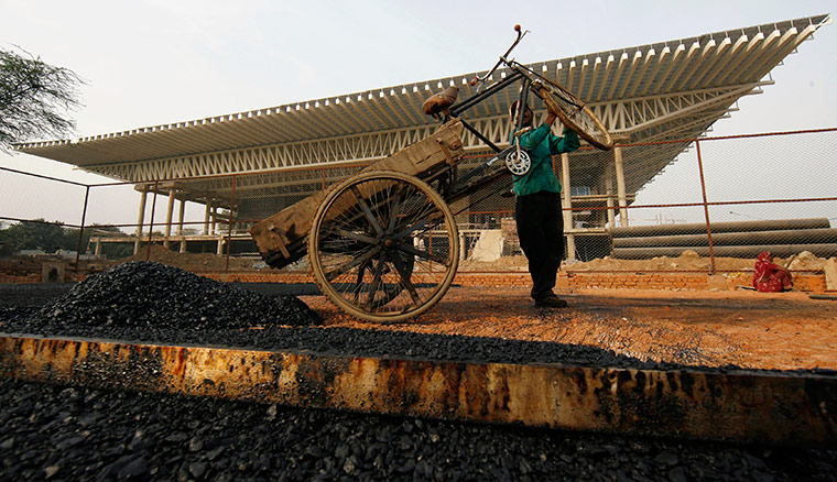 sport: Labourer works at the Thyagraj sports complex in New Delhi