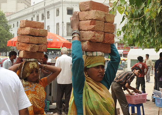sport: Indian labourers carry bricks