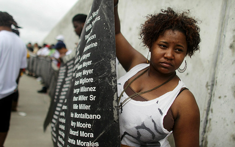 Obama in New Orleans: A mourner holds a banner listing names of victims during a healing ceremony