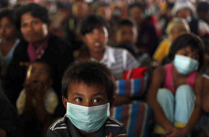 Mount Sinabung volcano: A boy sits on the floor as a band performs at a shelter 