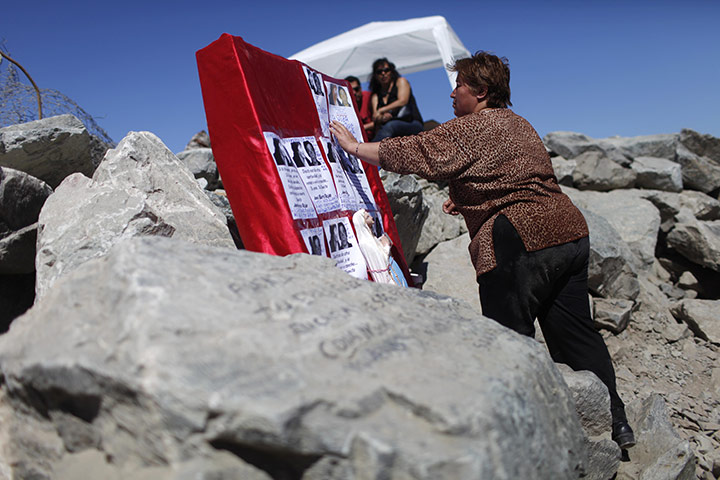 Miners in Chile: A relative of Yonni Barrio, one of 33 trapped miners, touches his portrait