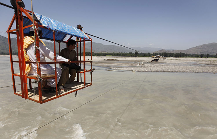 Pakistan Floods: Two men cross the Swat River in Pakistan's Swat Valley