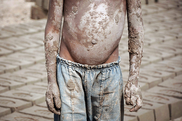 24 hours in pics: A boy helps his parents working at a brick Kiln, Pakistan