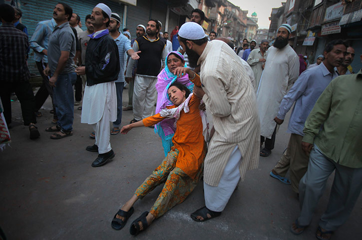 24 hours in pics: A relative a Kashmiri wounded in police firing is carried away