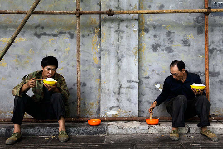 24 hours in pics: Construction workers eat their lunch at a construction site in Beijing