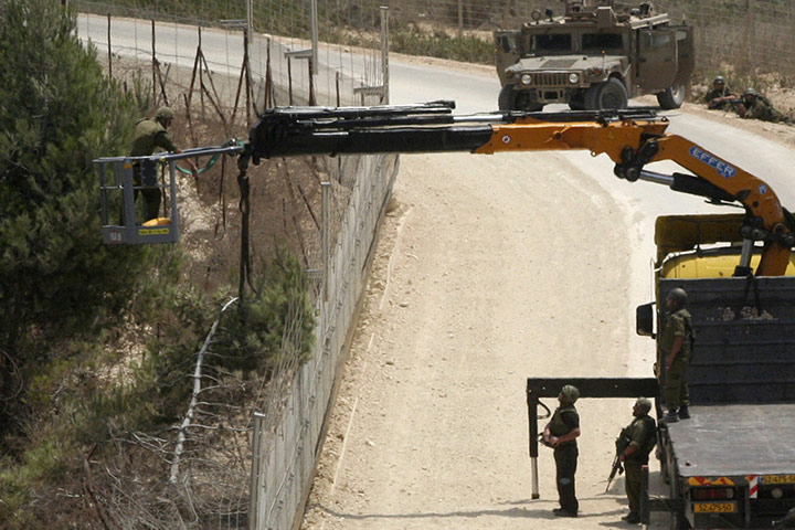 Israel and Lebanon clash: Israeli soldiers cut a tree