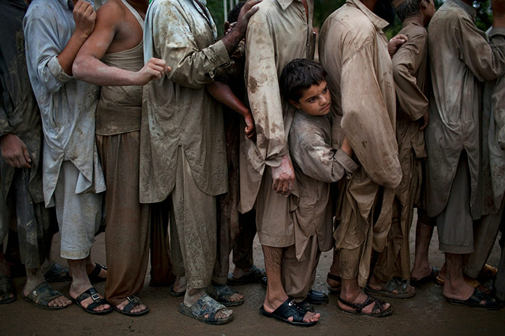 Pakistan flood : People line up to receive water relief supplie