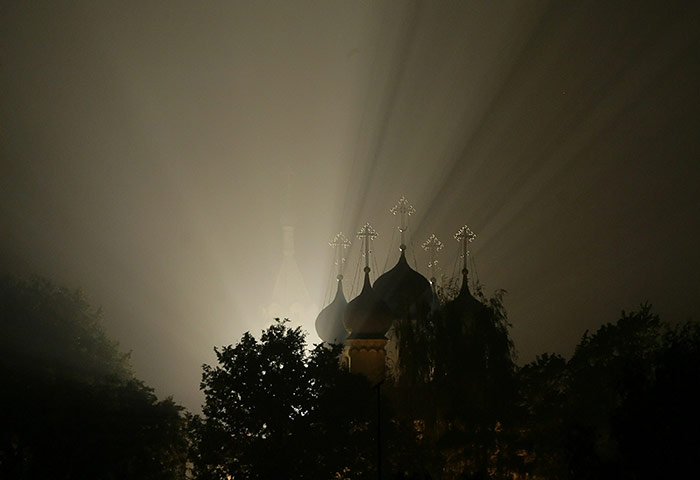 Russia update: Light shines through forest fire smoke near a Russian Orthodox church