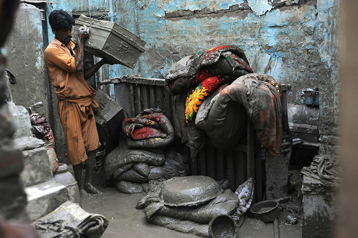 Pakistan update: A Pakistani flood survivor shifts mudsoaked belongings, Nowshera