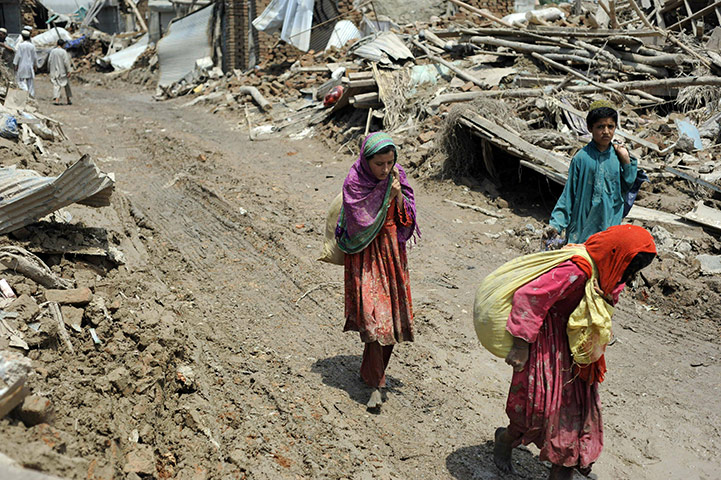Pakistan update: Flood survivors carry their belongings near Nowshera