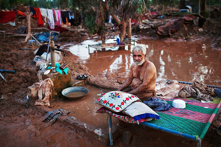 Pakistan update: A man rests after salvaging valuables from flooded destroyed home in Pabbi 