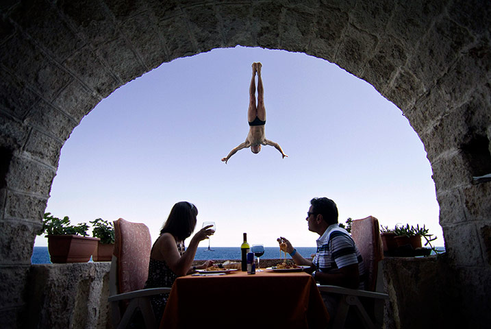 24 hours in pictures: Steve Black of Australia dives past balcony