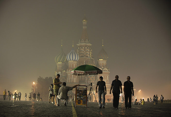 Russian Fires: Tourists walk past St. Basil's Cathedral in the heavy smog covering Moscow