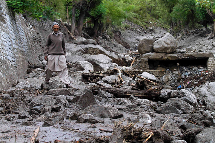 Leh flash floods: A local man walks through a road swept away by floodwaters in Kargil