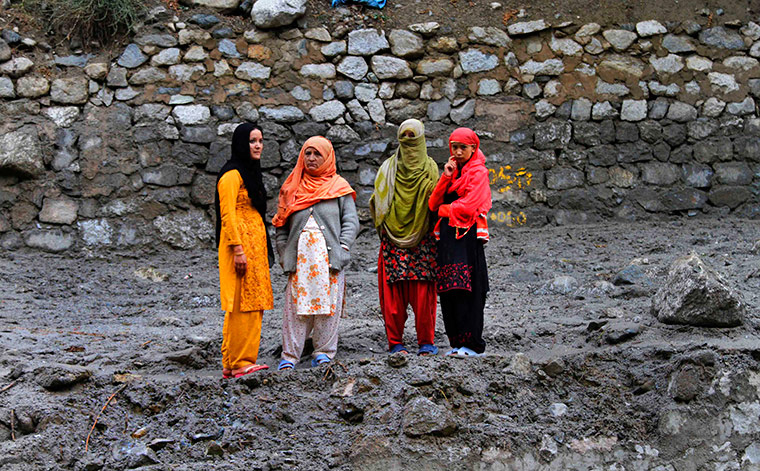 Leh flash floods: Women look on as they stand on the road swept away by flood in Kargil