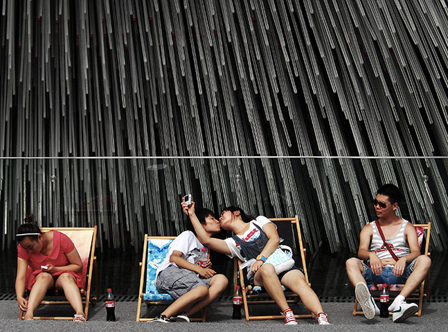 24 hours in pics: A young couple kiss as they take a photo of themselves, China
