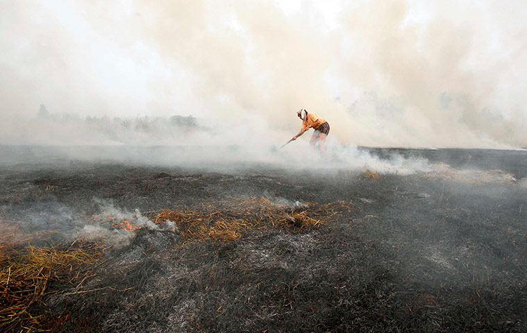 russia update: A resident works to extinguish flames to form a barrier