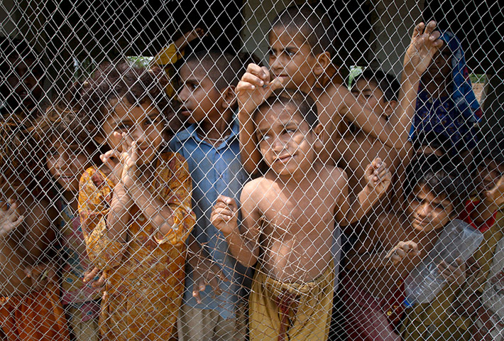 Pakistan update: Pakistan flood affected children look out from a grill 