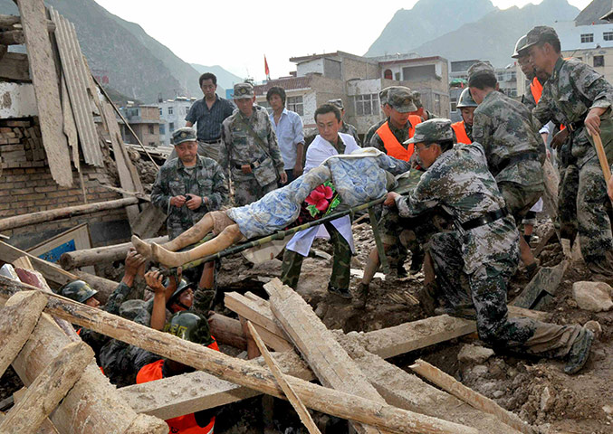 China Floods: Rescuers carry a survivor found after floods, China