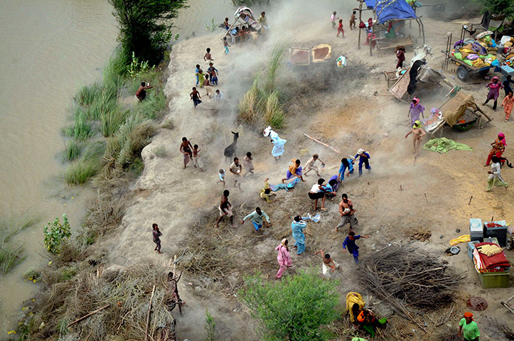 Pakistan aerial: Pakistani villagers chase to relief supplies dropped from army helicopter