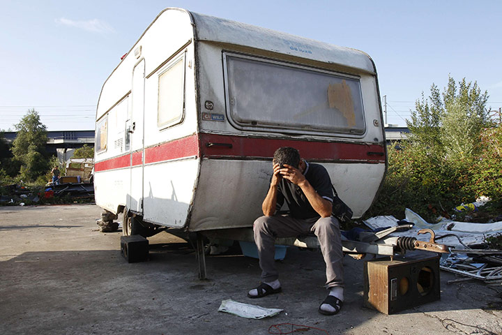 24 hours in pictures: A man sits outside a caravan in an illegal Roma camp in France