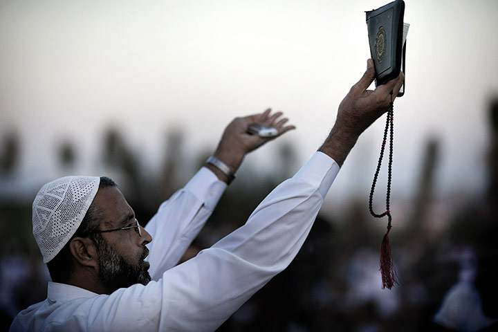 Eid begins: A Palestinian Muslim holds up a copy of the Qur'an 