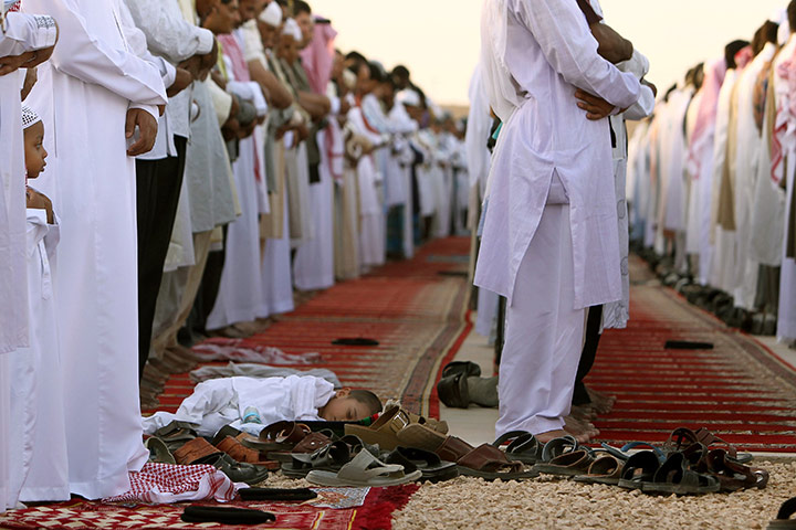 Eid begins: A child sleeps on the ground during Eid al-Fitr prayers in Diriyah