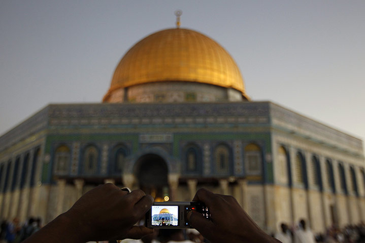 Eid begins: A Palestinian takes a photo of the Al-Aqsa Mosque before prayers 