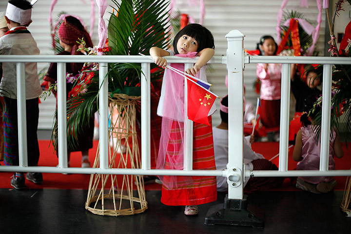 24 hours in pictures: A child with flags of China and Myanmar
