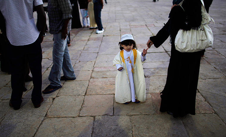 24 hours in picturess: A Palestinian woman reaches towards the hand of her son, Jerusalem