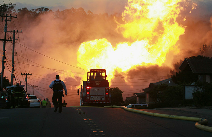 San Bruno fire: A law enforcement official runs towards a massive fire