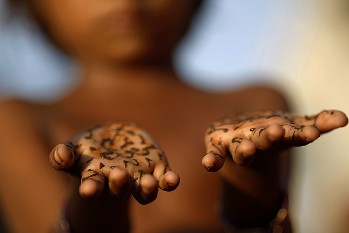 Eid festival: A flood victim shows her hands decorated with henna by aid workers