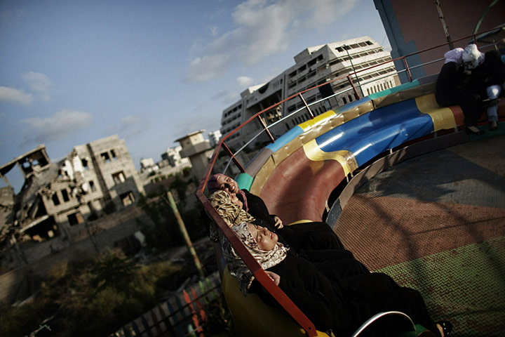 24 Hours: Palestinian girls enjoy a ride at an amusement park in the Gaza Strip 