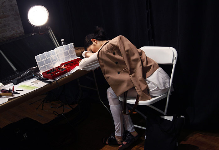 24 Hours: A model takes a nap backstage at New York Fashion Week